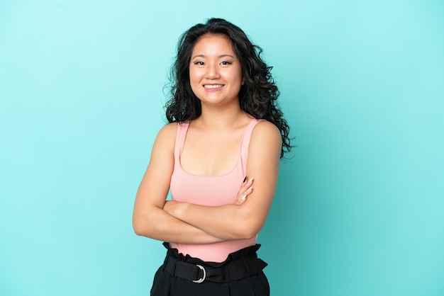 Young asian woman isolated on blue background keeping the arms crossed in frontal position