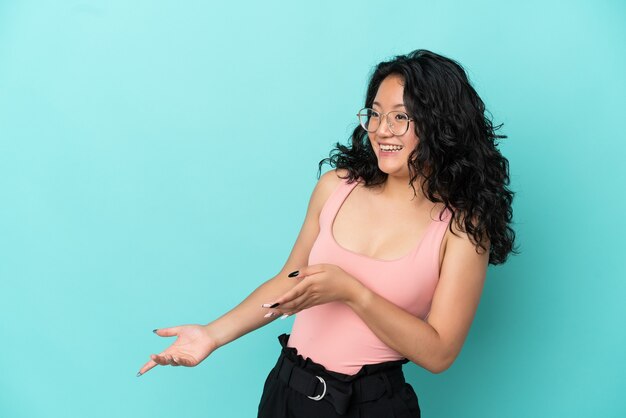 Young asian woman isolated on blue background with surprise expression while looking side