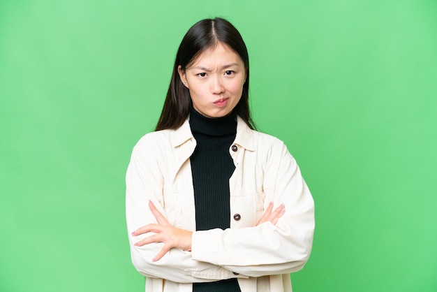 Young Asian woman over isolated chroma key background feeling upset