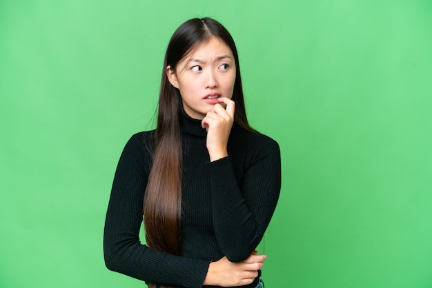 Young Asian woman over isolated chroma key background nervous and scared