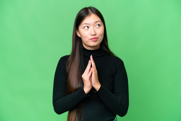 Young Asian woman over isolated chroma key background scheming something