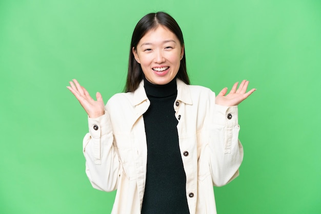 Young Asian woman over isolated chroma key background smiling a lot