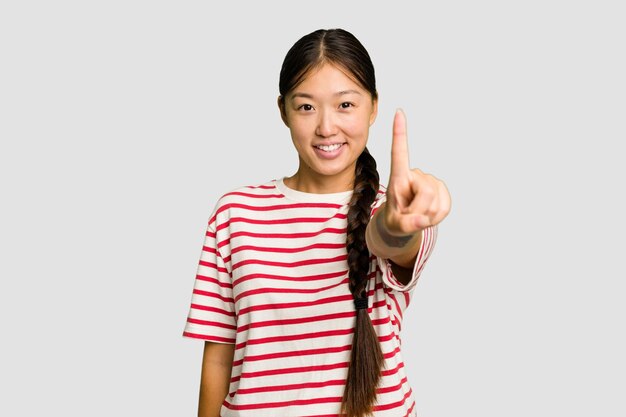 アジアの若い女性が指でナンバーワンを示しています