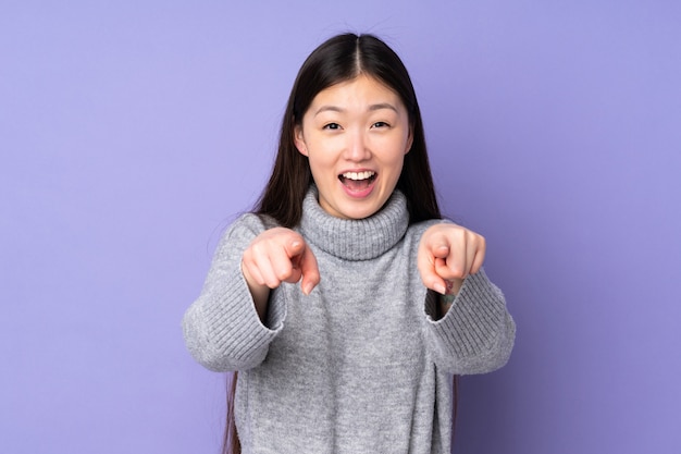 Young asian woman on isolated surprised and pointing front