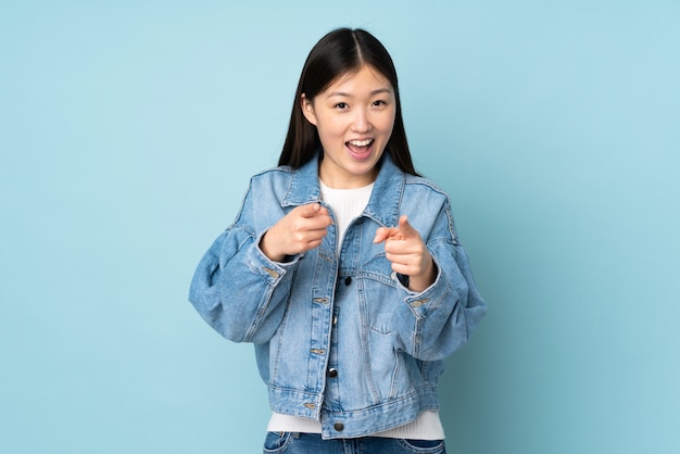 Photo young asian woman isolated on surprised and pointing front