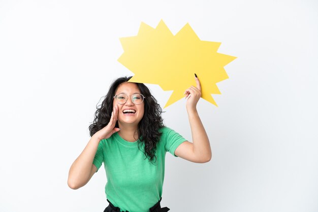 Young asian woman isolated on white background holding an empty speech bubble and shouting