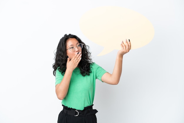 Young asian woman isolated on white background holding an empty speech bubble with surprised expression