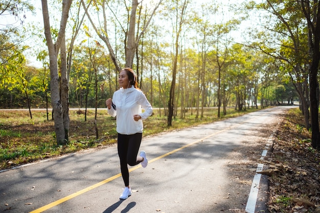 Una giovane donna asiatica che fa jogging nel parco cittadino al mattino