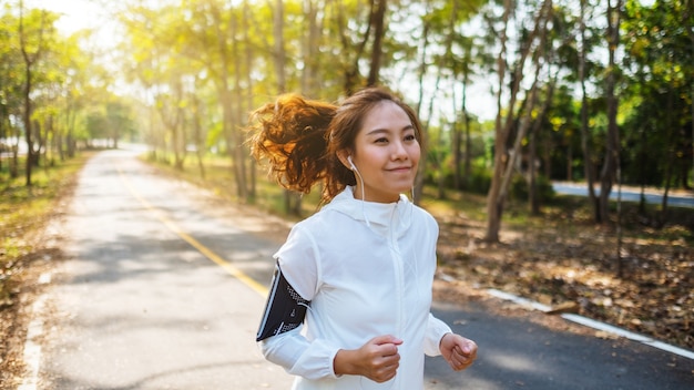 A young asian woman jogging in city park in the morning