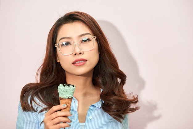 Young asian woman on light pink background. 