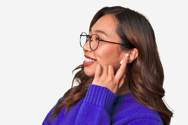 A young asian woman listening to music with wireless earbuds