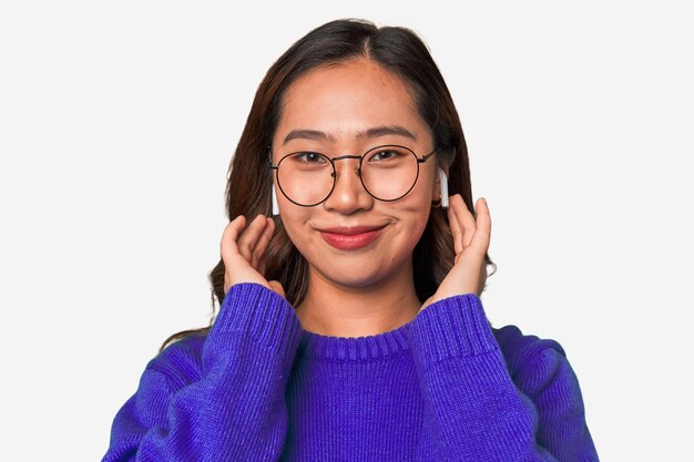 A young asian woman listening to music with wireless earbuds