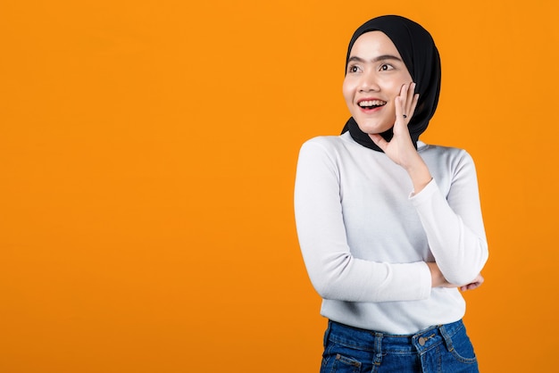 Young asian woman look happy and cheerful on yellow background