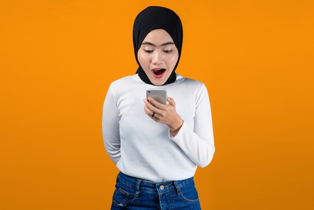 Young asian woman look shocked using mobile phone