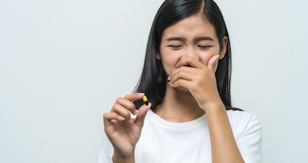 Young Asian woman looking at pill in hands