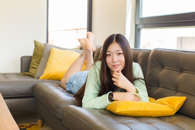 Young asian woman looking serious, confused, uncertain and thoughtful, doubting among options or choices