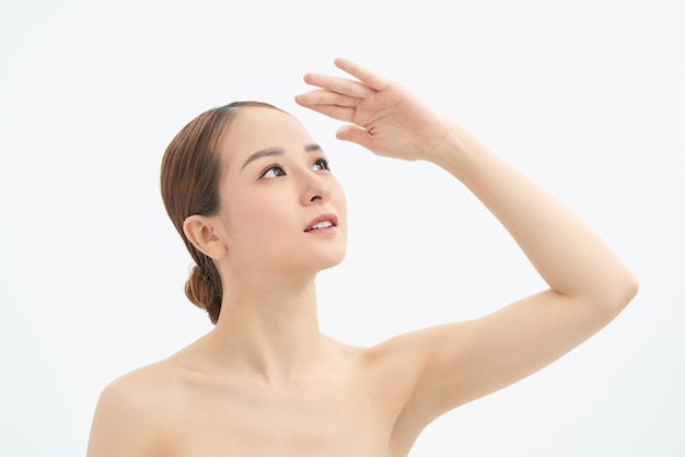 Young Asian woman looking up and showing hand to cover the light.