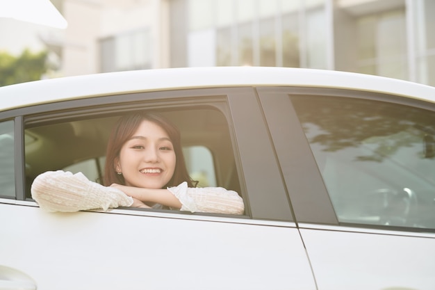 Young asian woman looks out of the car window