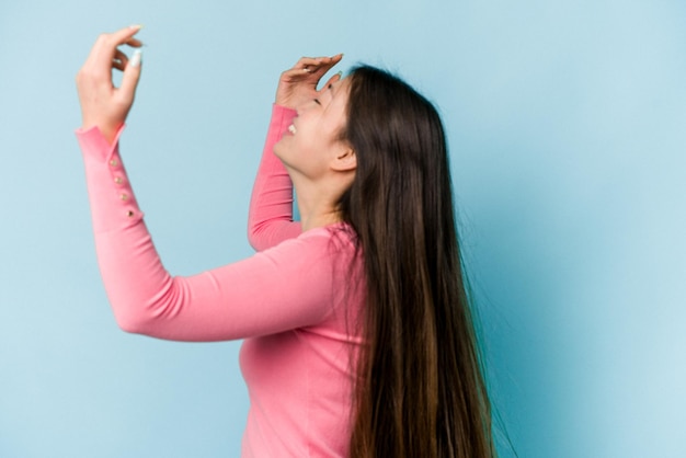 Young asian woman moving hair isolated on blue background