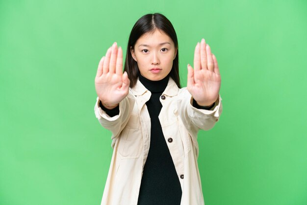 写真 孤立したクロマキーの背景に若いアジア人女性が停止のジェスチャーをして失望