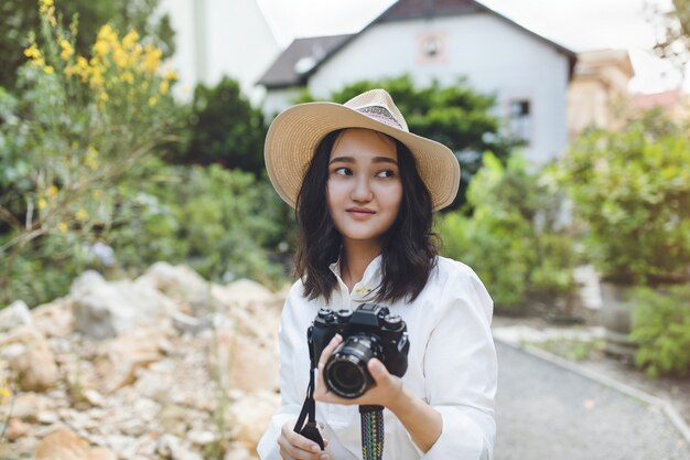 カメラ、屋外portratを保持している公園の若いアジア女性