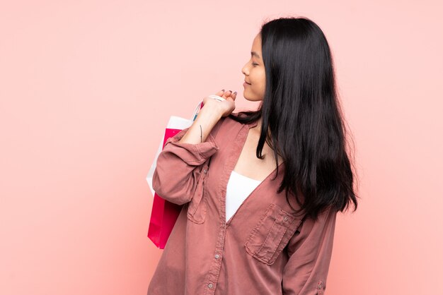 Young asian woman over pink wall