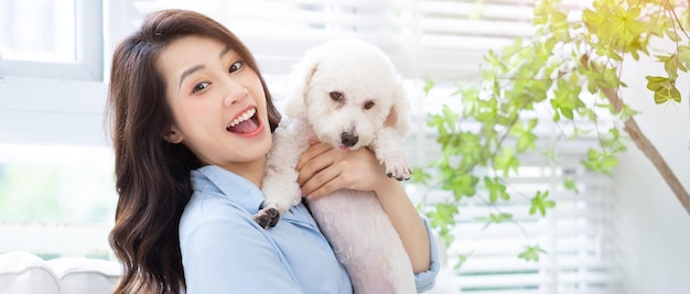 Young Asian woman playing with dog at home