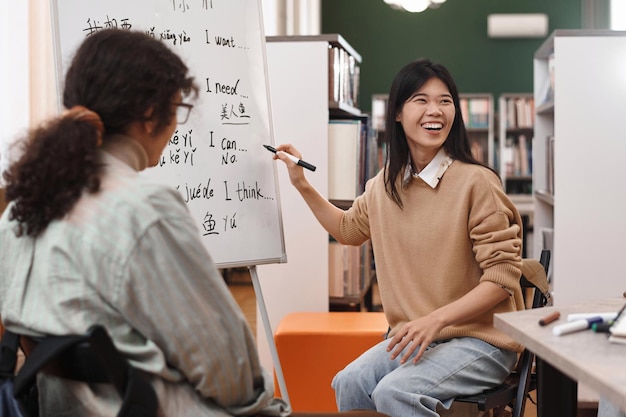 Young Asian Woman Pointing at Whiteboard with Hieroglyphs