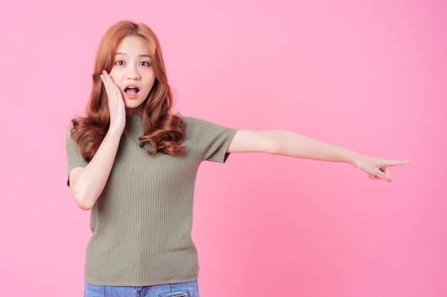 Young Asian woman posing on pink background