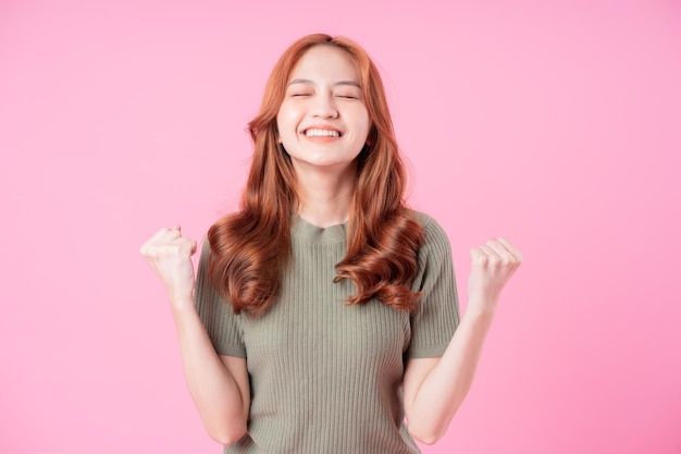 Young Asian woman posing on pink background