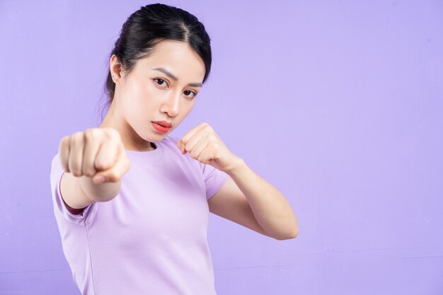 Young Asian woman posing on purple background