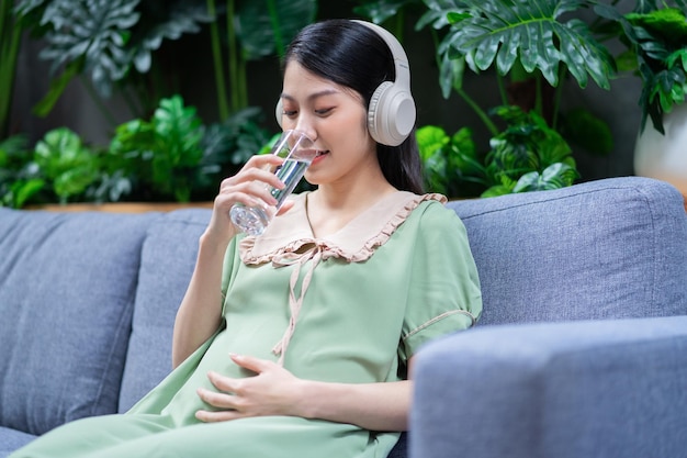 임신한 젊은 아시아 여성 집에서 휴식