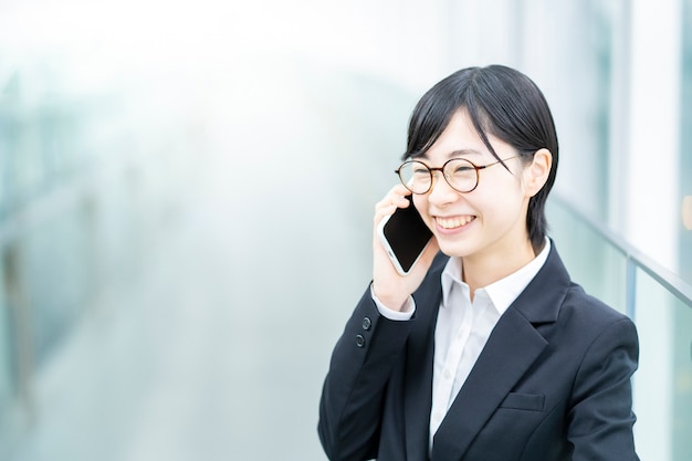 Young Asian woman in a professional suit talking on the phone