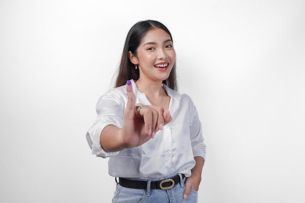 Photo young asian woman proudly showing little finger dipped in purple ink after voting for president and parliament election expressing excitement and happiness