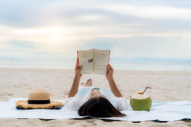 Young Asian woman reading a book on the beach