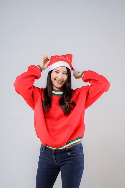 Photo young asian woman in a red sweater and santa hat