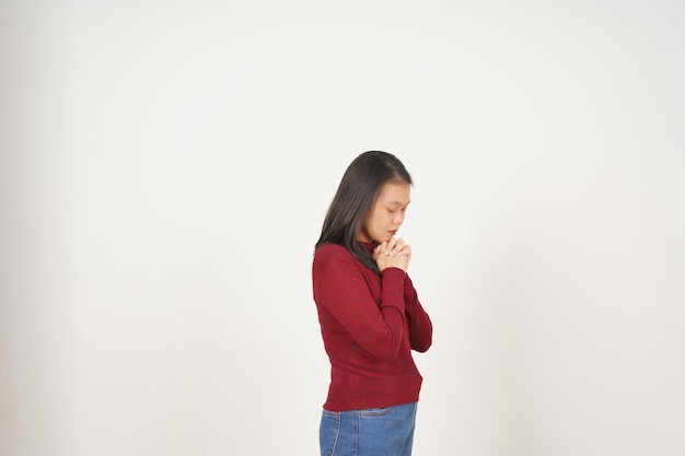 Young Asian woman in Red tshirt closed eye fold hand and praying isolated on white background