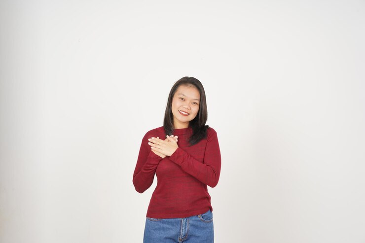 फोटो young asian woman in red tshirt hand on chest grateful concept isolated on white background