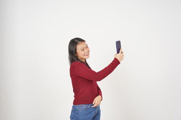 Photo young asian woman in red tshirt take a selfie photo isolated on white background