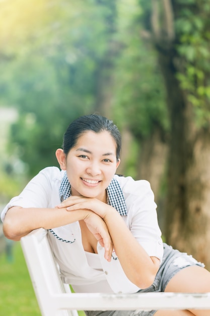 Young asian woman relaxing outdoors looking happy and smiling