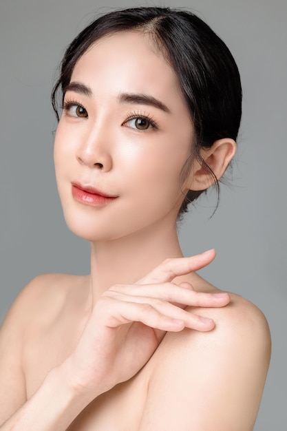 Young asian woman short hair with natural makeup on face and clean fresh skin on isolated grey background portrait of cute female model in studio facial treatment cosmetology