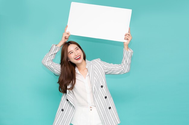 Photo young asian woman showing and holding blank white billboard