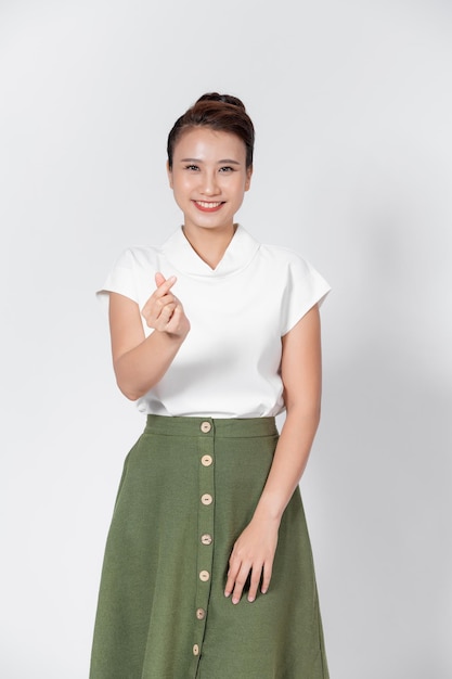 Young Asian woman showing mini heart sign isolated on white background