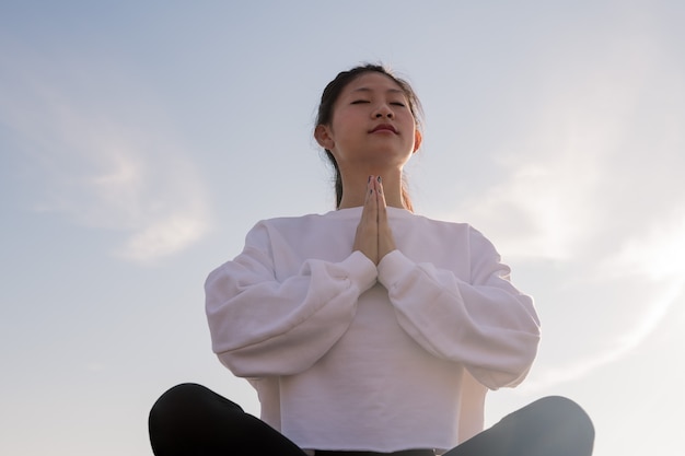 Photo young asian woman sitting meditating at morning