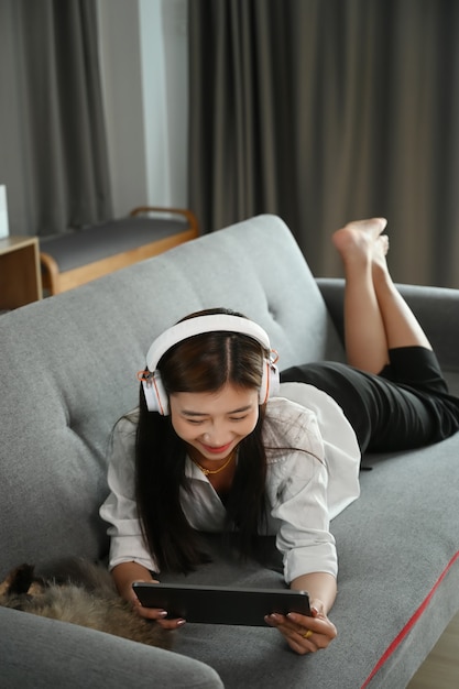 Young Asian woman sitting on a sofa watching a movie