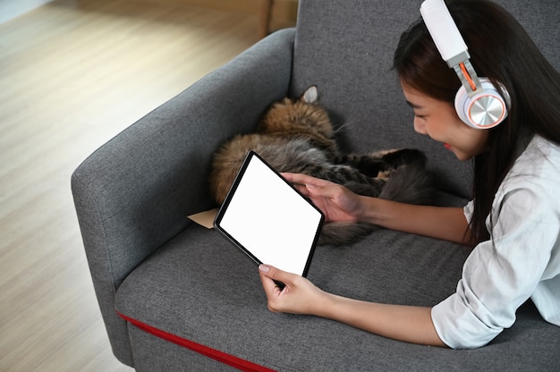 Young Asian woman sitting on a sofa watching a movie