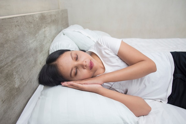 Young asian woman sleeping on a bed