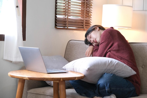 Young asian woman sleeping break time or off line mode after using laptop relax sitting on couch or sofa people lifestyle at home digital detox concept