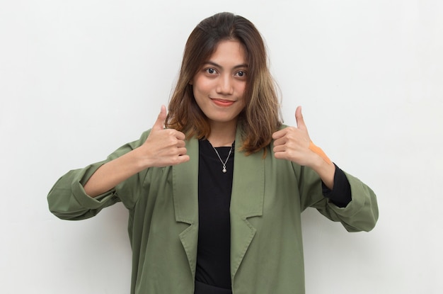 Молодая азиатская женщина улыбается и делает знак ОК с жестом руки