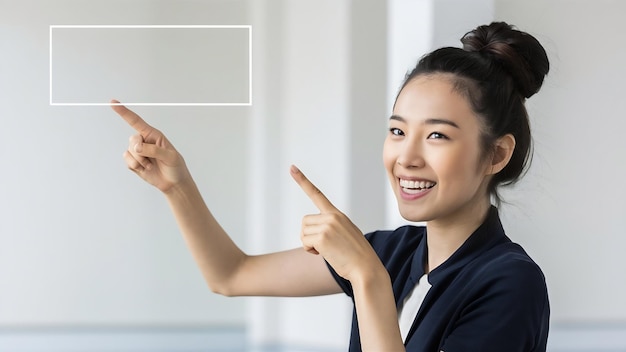 Young asian woman smiling and pointing finger to empty copy space isolated on white background